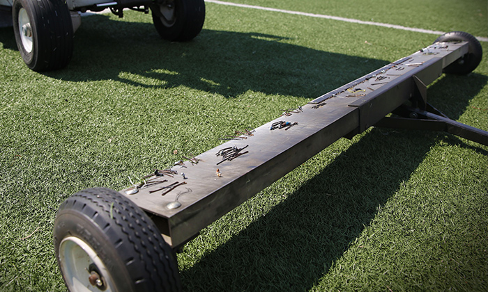 Clean Sweep Cleaning Service magnet removing unwanted debris from artificial turf football field.